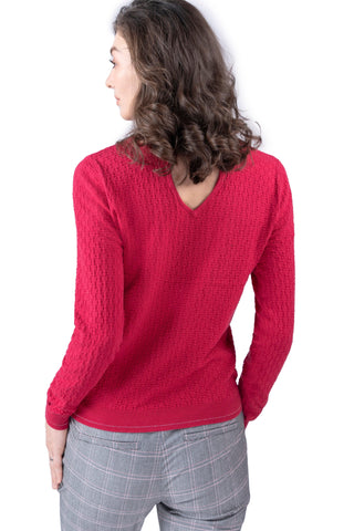 Vue arrière du pull en maille rose vif montrant le détail découpé dans le dos.